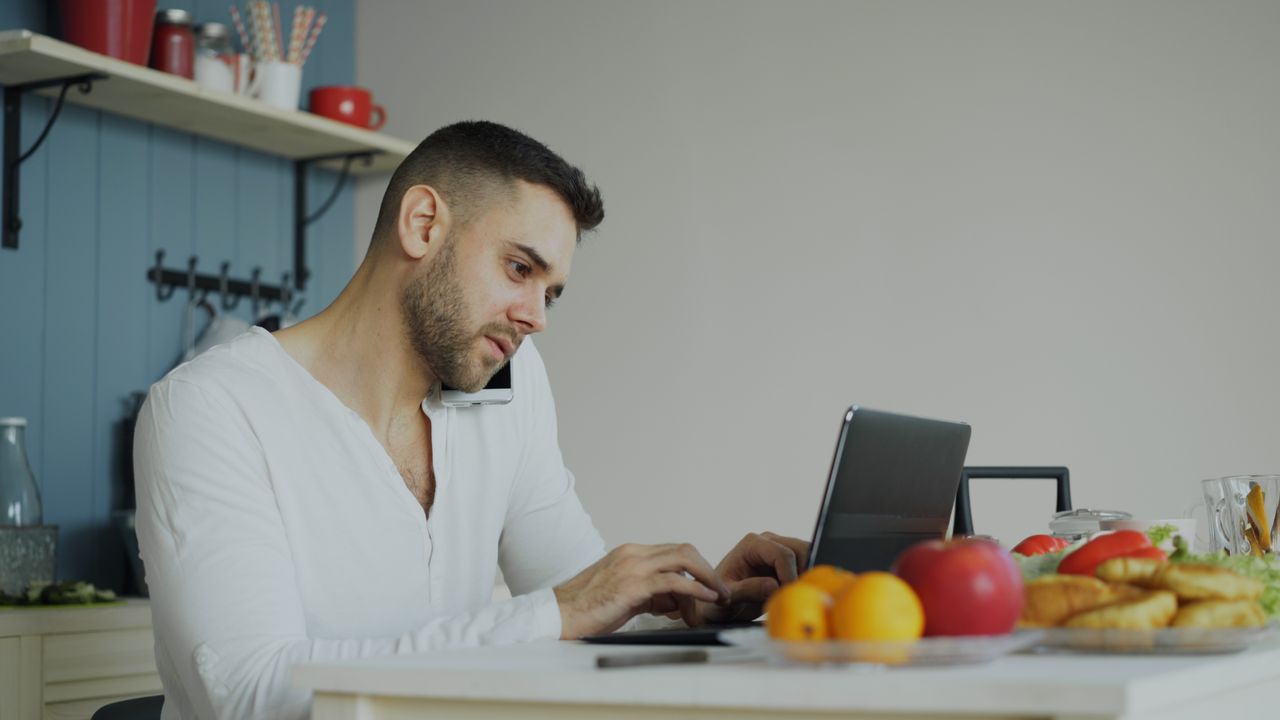 man-working-remotely-in-kitchen-with-laptop-36763311-tKkI4F88NLn16FgsY6kx